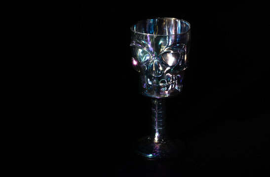 una copa de calavera o craneo de pl&aacute;stico tornasol decorativa de fiesta de halloween  con fondo negro