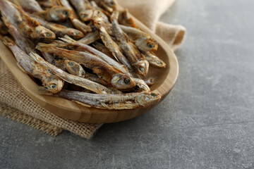 Delicious dried anchovies on grey table, closeup