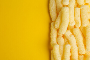 Tasty corn sticks on yellow background, top view. Space for text
