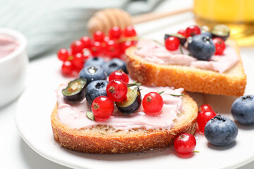 Tasty sandwiches with cream cheese, berries and honey, closeup