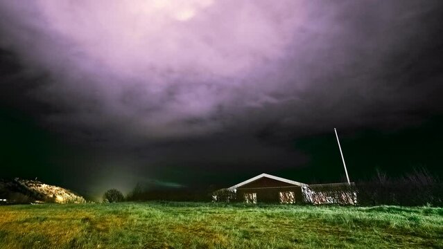 Night stormy clouds motion time lapse - aurora borealis and lonely rural house whith stormy skyes Nothern lights nature background