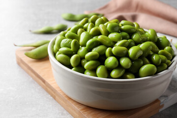 Bowl of delicious edamame beans on table, closeup