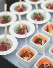 Catering table, beautifully decorated banquet with variety of with different food snacks appetizers on corporate birthday party event or wedding celebration, canape, salad, delicatessen setting