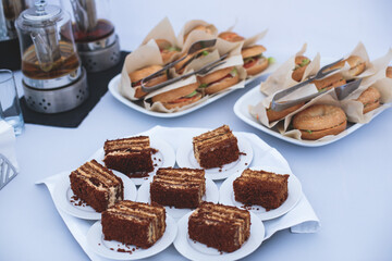Catering table, beautifully decorated banquet with variety of with different food snacks appetizers on corporate birthday party event or wedding celebration, canape, salad, delicatessen setting