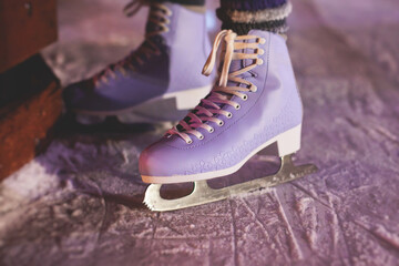 Close up view of new purple violet pink ice skates boots on rink in motion, girl ice skating on...