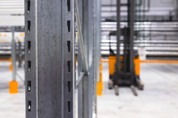 Modern large warehouse space interior, new and modern distribution storage with rows of empty high shelves and racks, concrete and steel, logistics complex inside