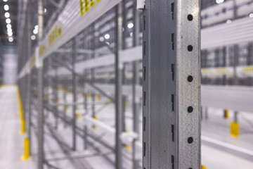 Modern large warehouse space interior, new and modern distribution storage with rows of empty high shelves and racks, concrete and steel, logistics complex inside