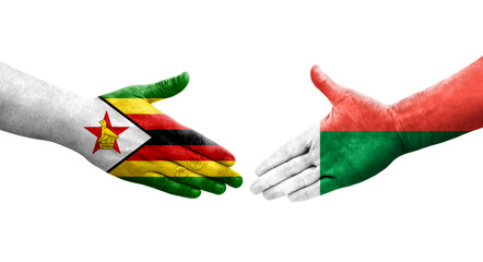 Handshake between Madagascar and Zimbabwe flags painted on hands, isolated transparent image.