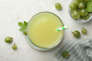 Tasty gooseberry juice and fresh berries on light table, flat lay