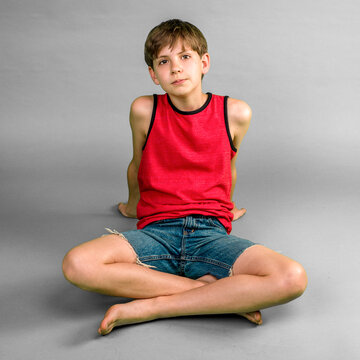 Child Boy Sitting Criss Cross In Shorts in Studio