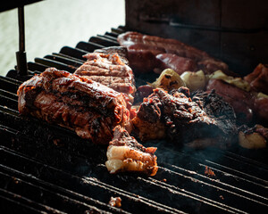Churrasco na grelha, carne de boi vermelha assando com linguiça e outras carnes 