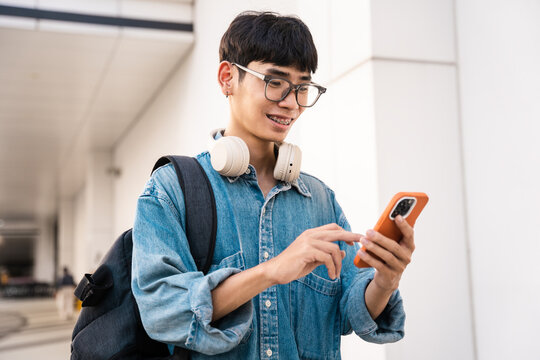 A picture of an Asian male student using a mobile phone