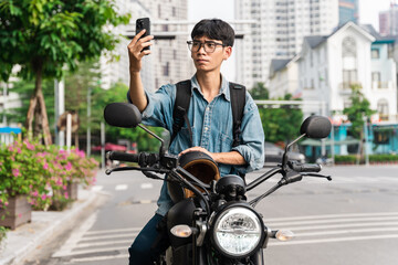 Fototapeta na wymiar image of asian man, sitting on moto using mobile phone