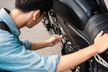 Young Asian man repairing motorbike