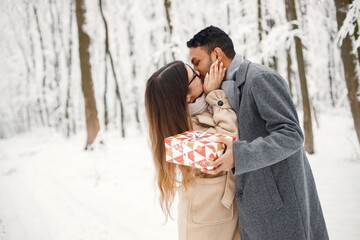 Portrait of a romantic couple spending time together in winter forest