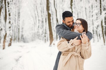 Portrait of a romantic couple spending time together in winter forest