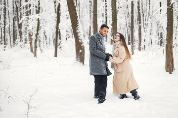 Fototapeta na wymiar Portrait of a romantic couple spending time together in winter forest