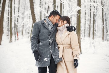 Fototapeta na wymiar Portrait of a romantic couple spending time together in winter forest