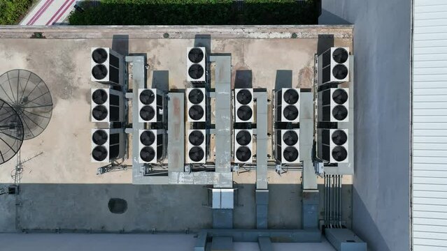 Bird eye view of many rooftop air compressor unit working slowly and hard on white metal sheet rooftop