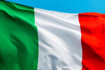 Italian flag waving on blue background