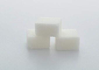 Three sugar cubes on white background