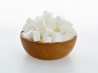 Sugar cubes in a bowl on white background