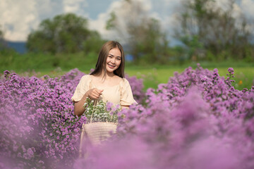 Woman with a bouquet of flowers in a basket in a field