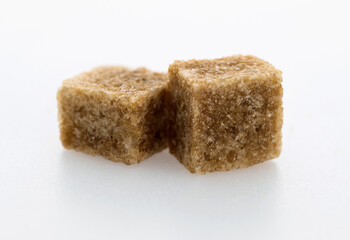 Brown sugar cubes on white background