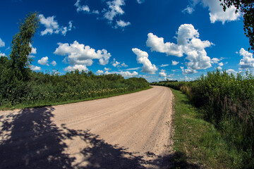 Beautiful summer gravel road with clouds - 539623170