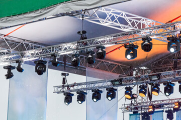 lighting equipment with spotlights under roof of outdoor stage during the rain. lighting equipment of outdoor concert stage.