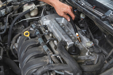 Fototapeta premium Auto mechanic checking spark plugs from the old motor.