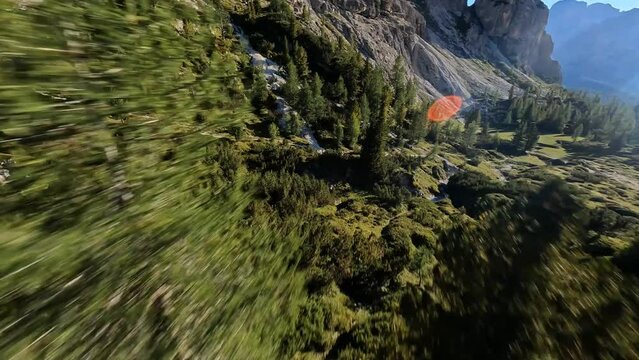 flying gliding through the Dolomites mountain range in Italy Tirol. mountain forest and grass hiking paradise adventure alp terrain. FPV race drone aerial.