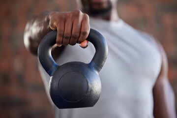 Fototapeta premium Fitness, bodybuilder and black man kettlebell training, exercise or workout for powerful arm strength at gym. African, hand and strong sports athlete bodybuilding or weightlifting in a health club