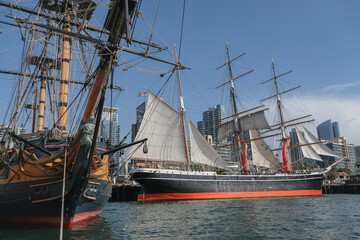 View over downtown port harbor with historic windjammer sailing boats and modern San Diego skyscraper skyline on sunny day