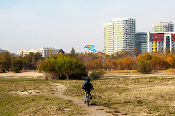 Obraz premium a boy rides a bicycle with a kite