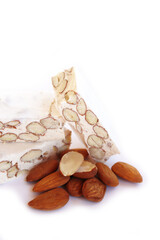 Traditional italian festive Torrone di Cremona ( white Nougat) with almonds cut in pieces isolated on white background