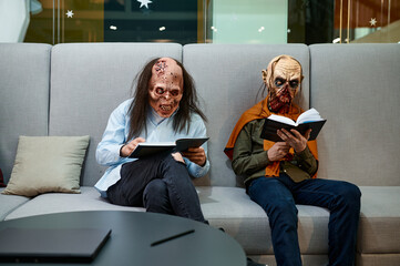 Zombie employees reading sitting on sofa