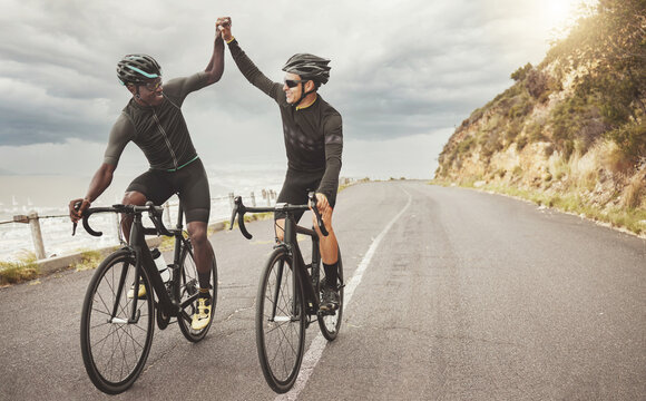 Bike, friends and men high five on road having fun cycling together outdoors. Success, diversity and teamwork of male cyclists on bicycles riding on street, exercise or workout training on asphalt.