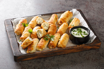 borek sigara boregi fried pastry wrapped in cheese in phyllo closeup on the wooden board on the...