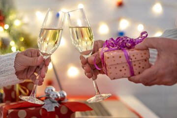Two people's hands toasting with sparkle wine glass celebrating Christmas holidays. Happiness and love. Merry Christmas and happy new year