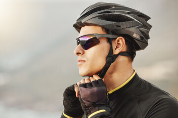 Cycling, helmet and sunglasses with a sports man being safe while outdoor for a ride on a cloudy...