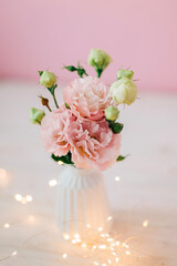 Beautiful pink bouquet of flowers in the vase on the table. Cozy home decoration and festive decor