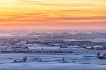 Fototapeta na wymiar Freight train in a winter landscape at sunset
