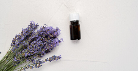 Herbal oil and lavender flowers isolated on white concrete background, top view, flat lay