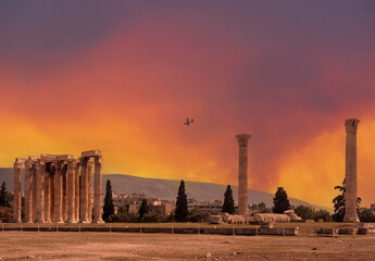 The plane extinguishes a fire on the background Antique marble Temple of Olympian Zeus in Athens, Greece