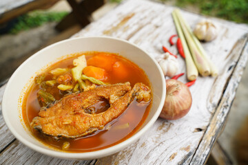 Tamarind curry with fried fish and vegetables on wooden floor - Thai style  That is delicious and has been very popular.