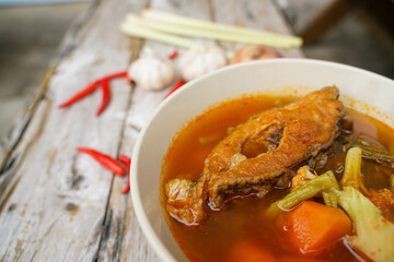 Tamarind curry with fried fish and vegetables on wooden floor - Thai style  That is delicious and has been very popular.