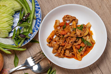 Pork stir fried in chili paste with tomatoes and onions in a white dish