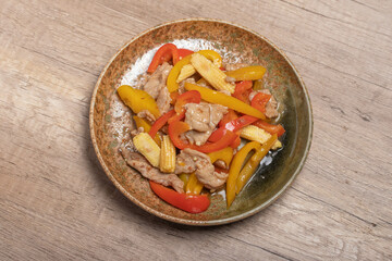 Stir-fried pork with sweet peppers in a brown dish