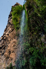 A waterfall falls in the middle of the road in Ponta do Sol, Madeira